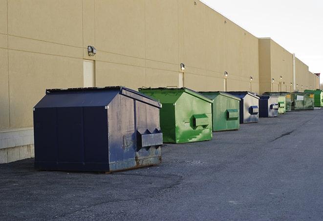 a group of dumpsters lined up along the street ready for use in a large-scale construction project in Edison